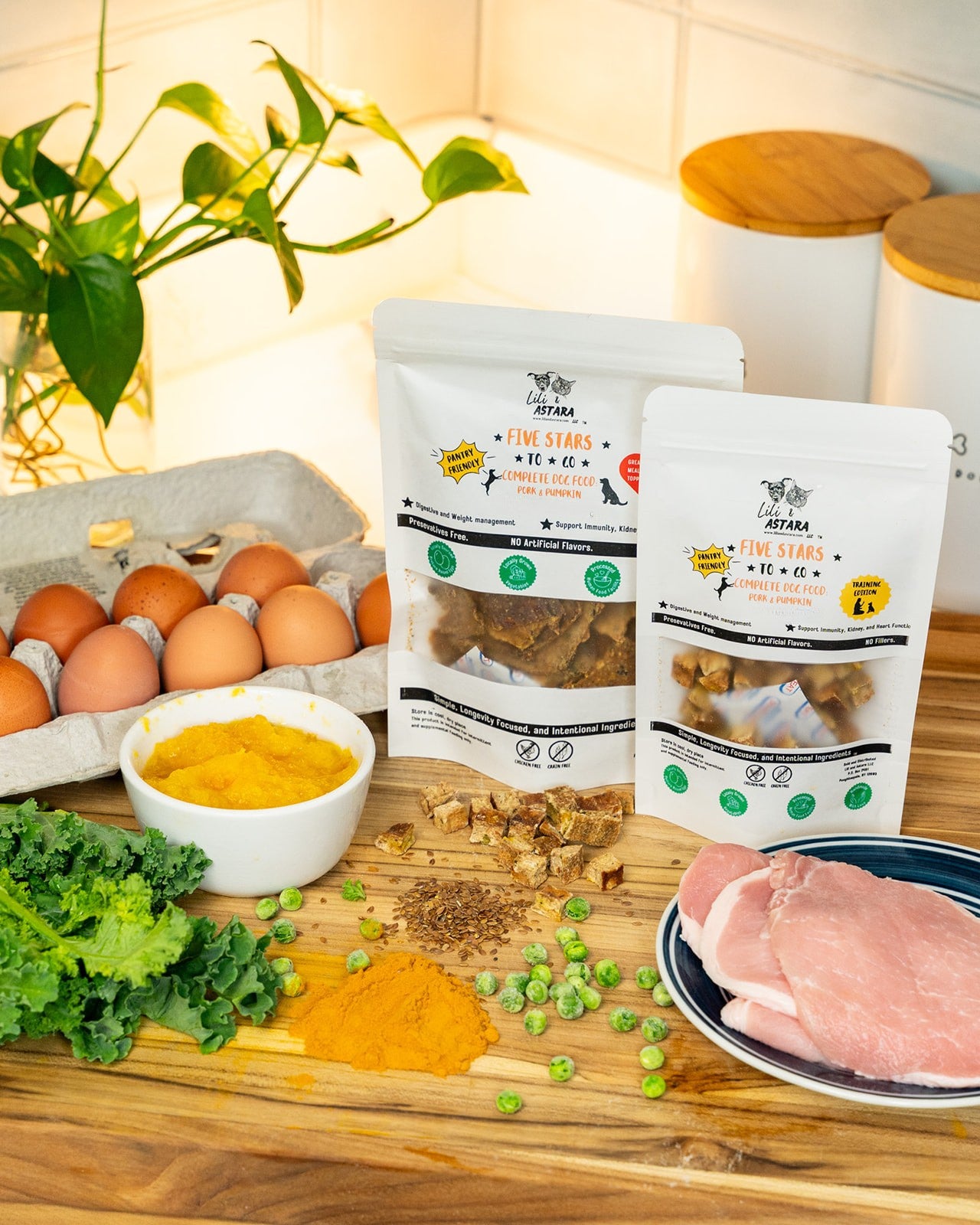 Raw Pork loin, eggs, vegetables, and dog food packages on a wooden surface.